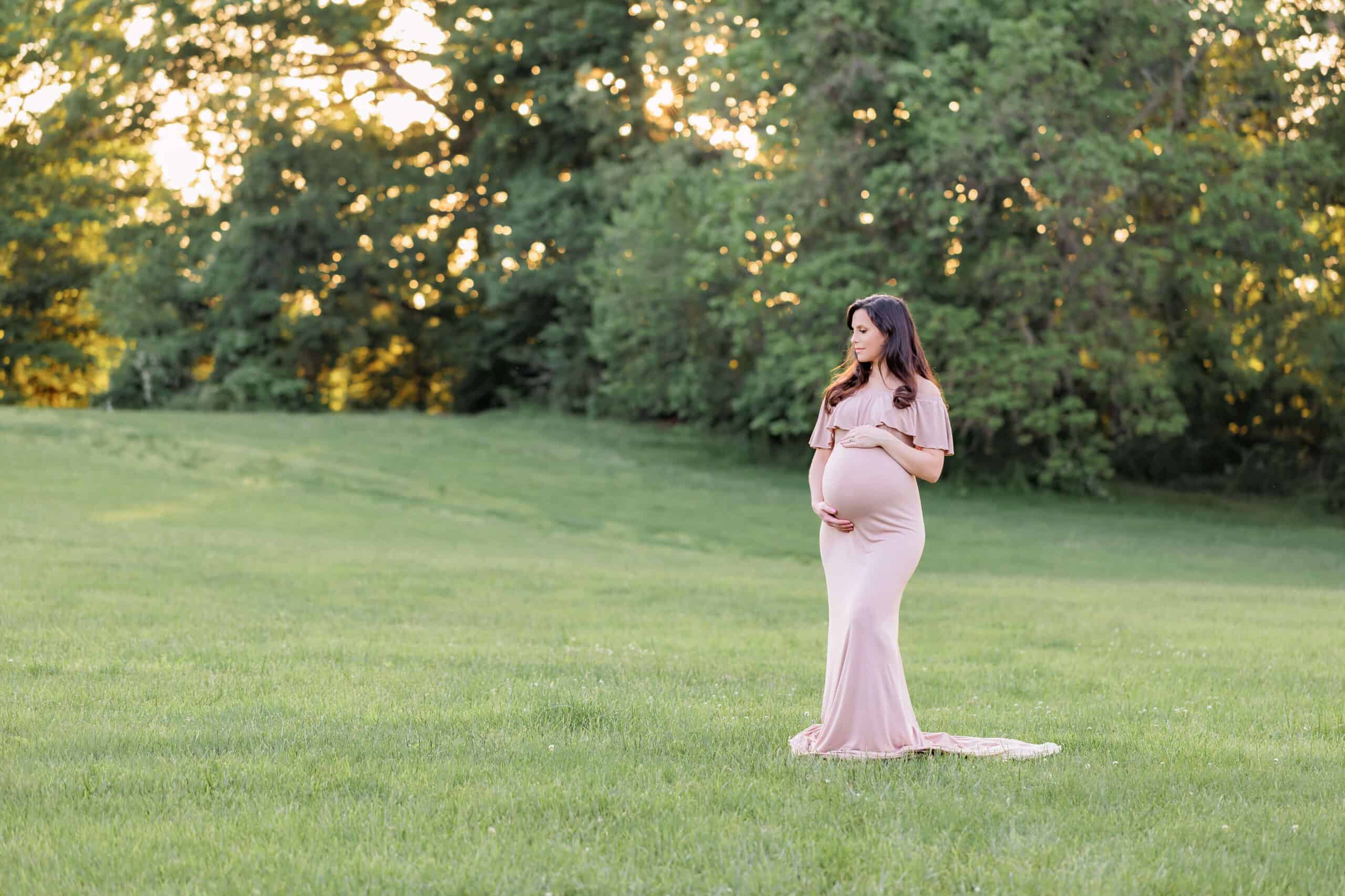 A blog about prenatal chiropractors in Northern Virginia featuring a photo of a mother-to-be in a tan dress standing in a field at sunset.