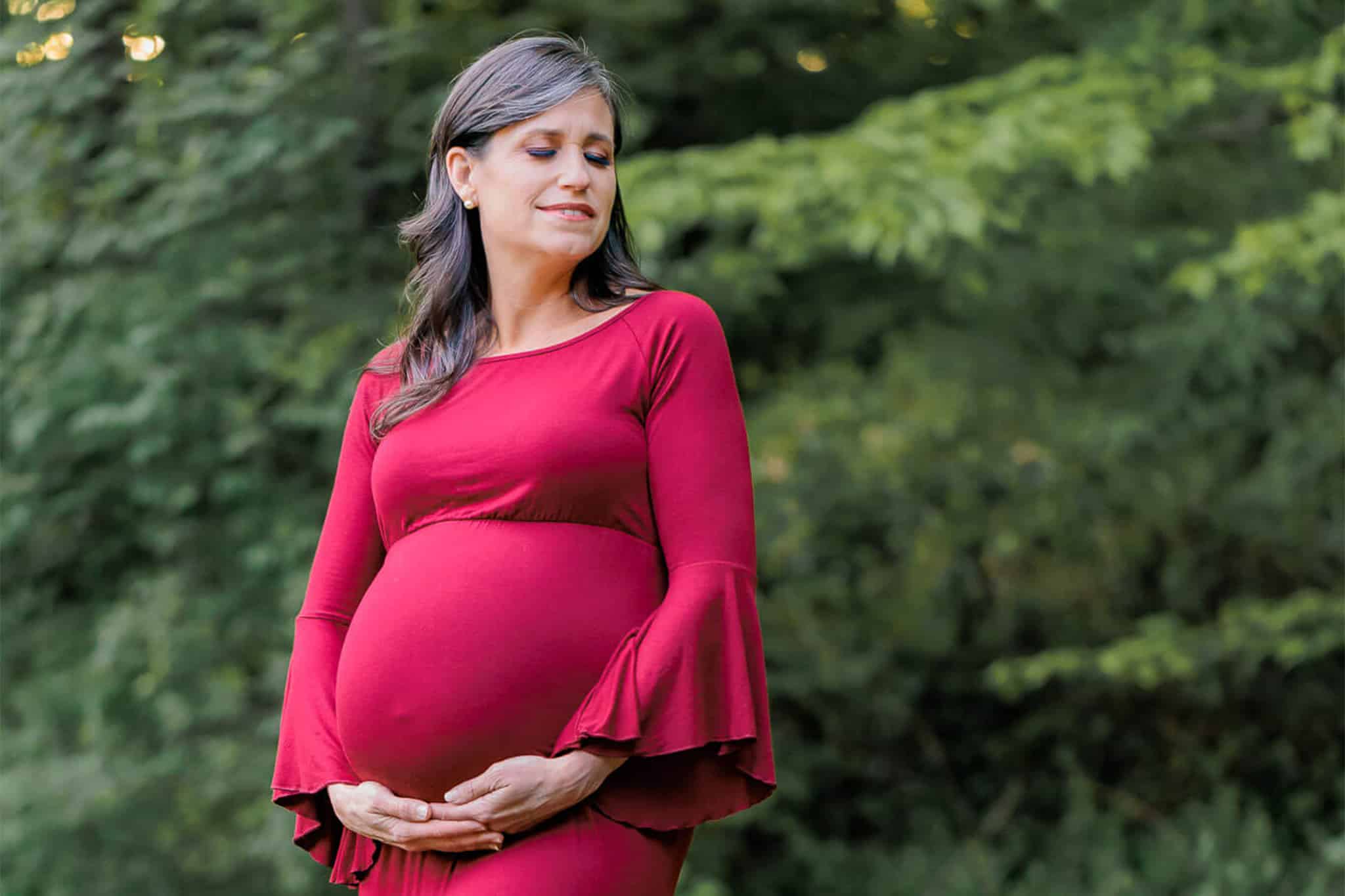 A blog about prenatal massages at A Touch of Serenity featuring a pregnant woman in a red dress in the woods.