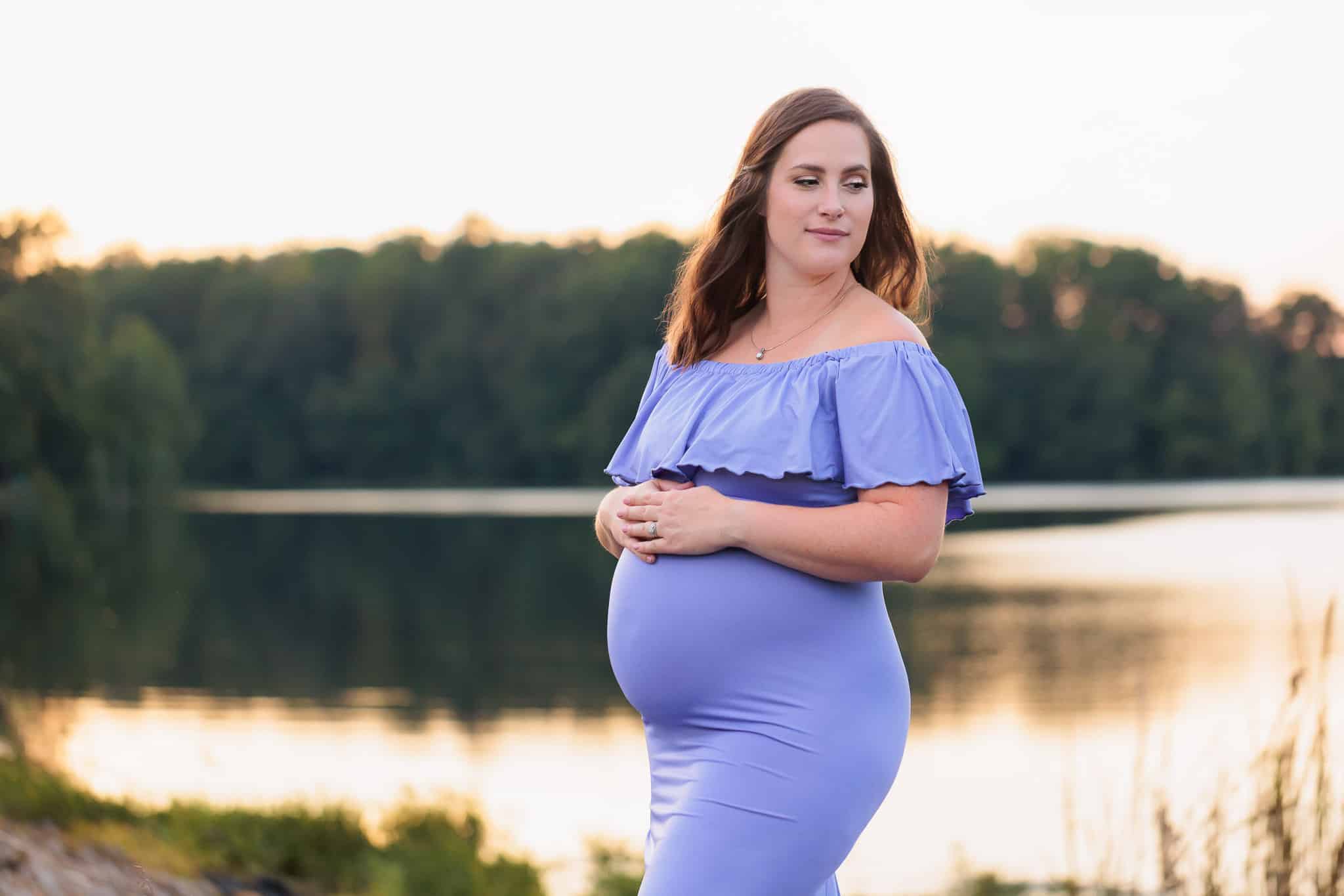 A mother-to-be in a purple gown posing in front of Burke Lake featured on a blog post about Clarifying Spaces, professional organizer in Northern Virginia.