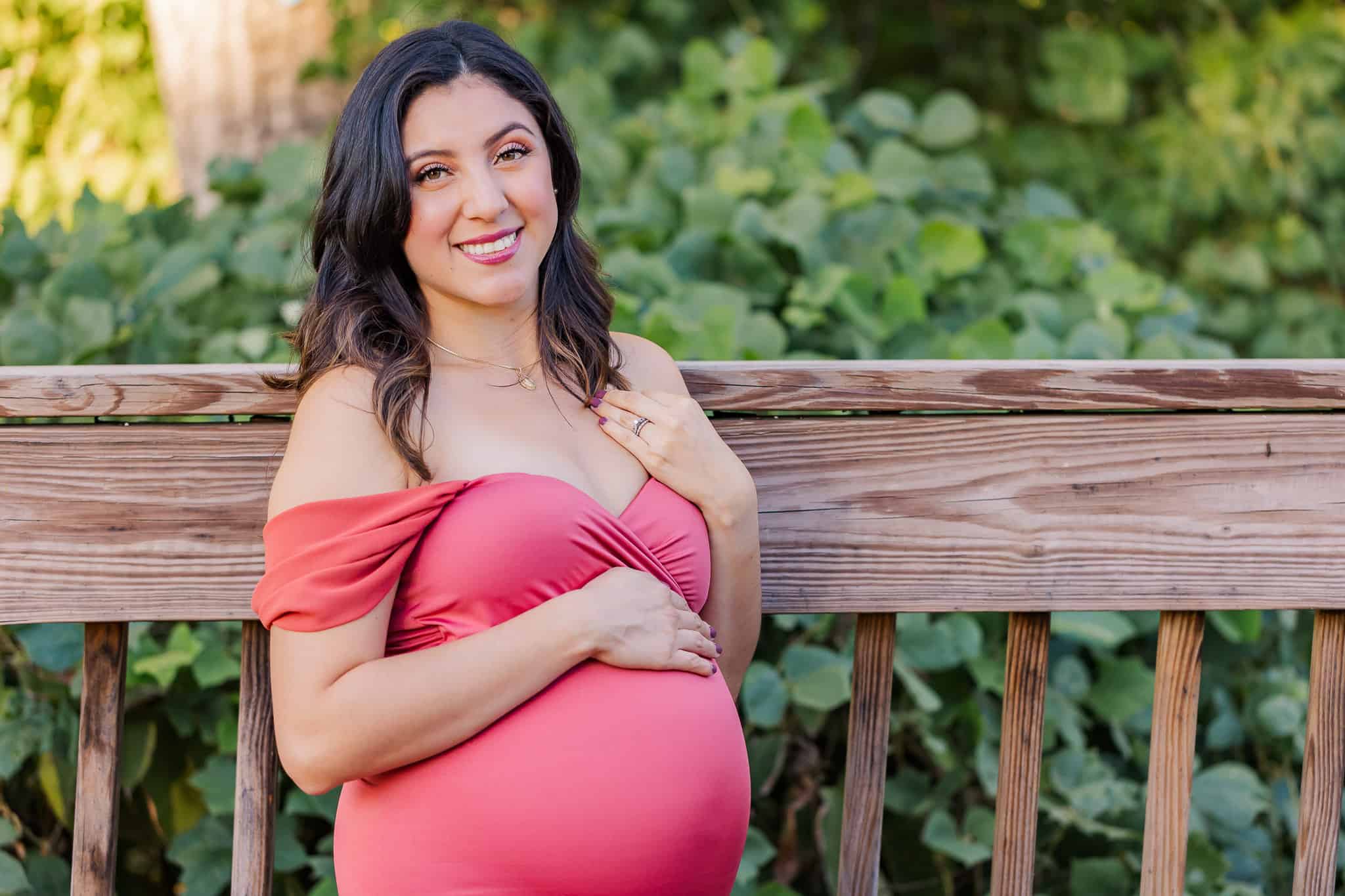 A mom-to-be standing on a bridge and holding her belly, featured on a blog about 529 Kids Consign.
