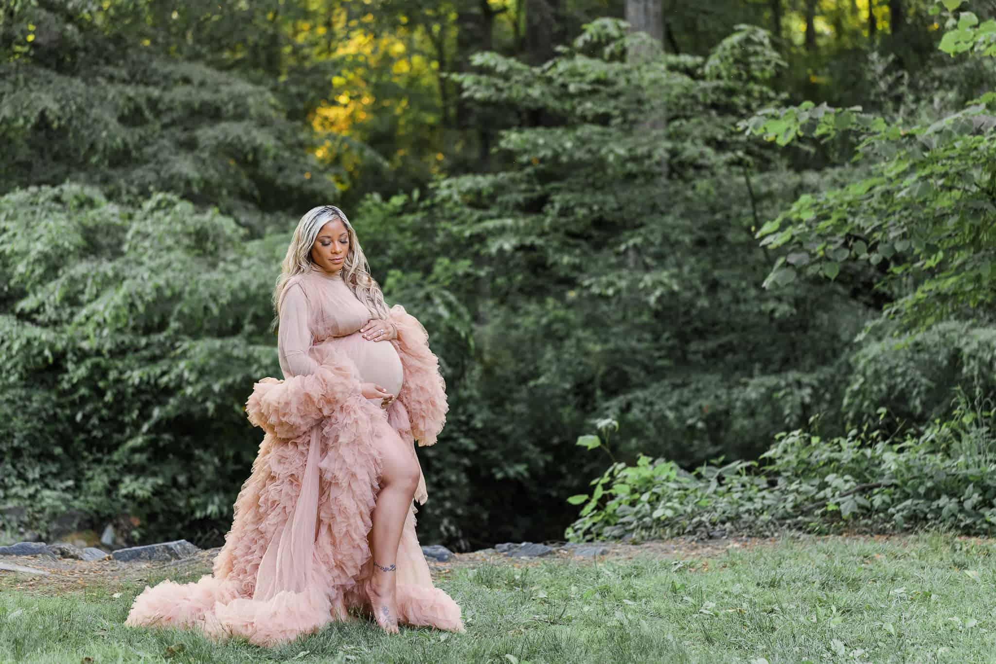 A beautiful mom to be in a nude body suit and tulle robe at Ellanor C Lawrence Park at sunset.