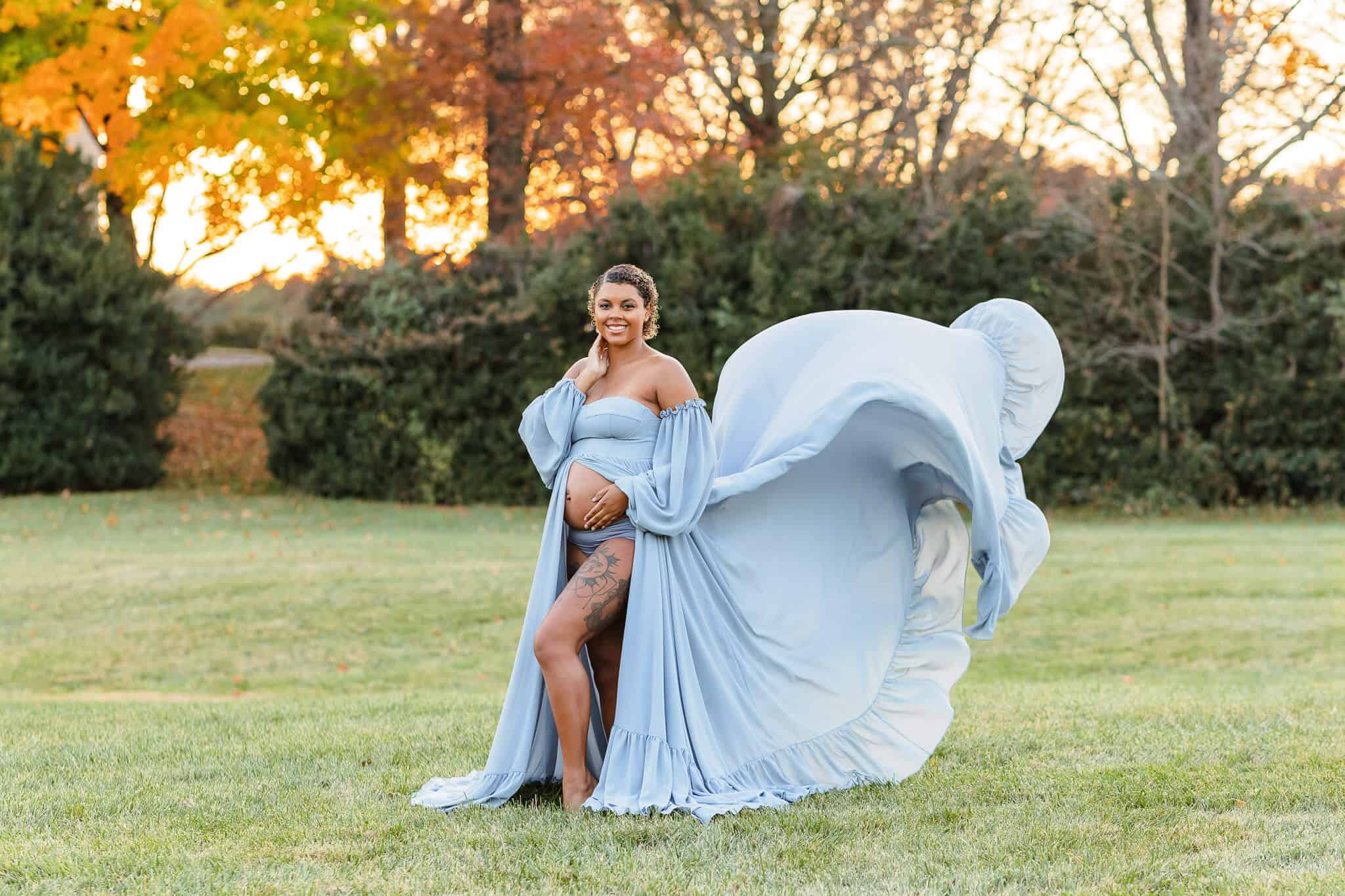 A pregnant mom wearing a flowing blue dress at sunset featured on a blog about Balanced Birth Support.