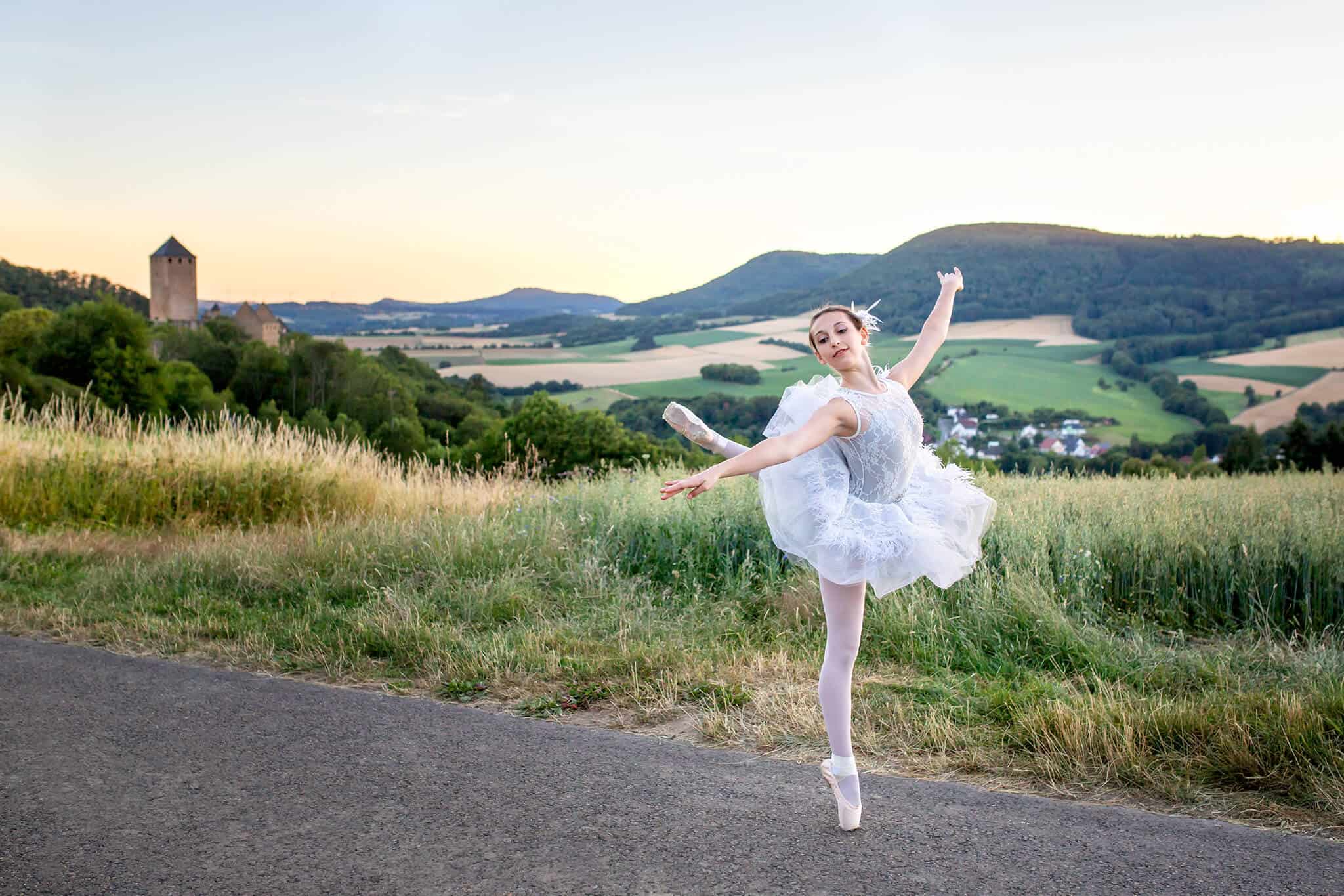 A ballerina posing in front of a field and castle, featured on a blog post about Buffa's Dance Studio.
