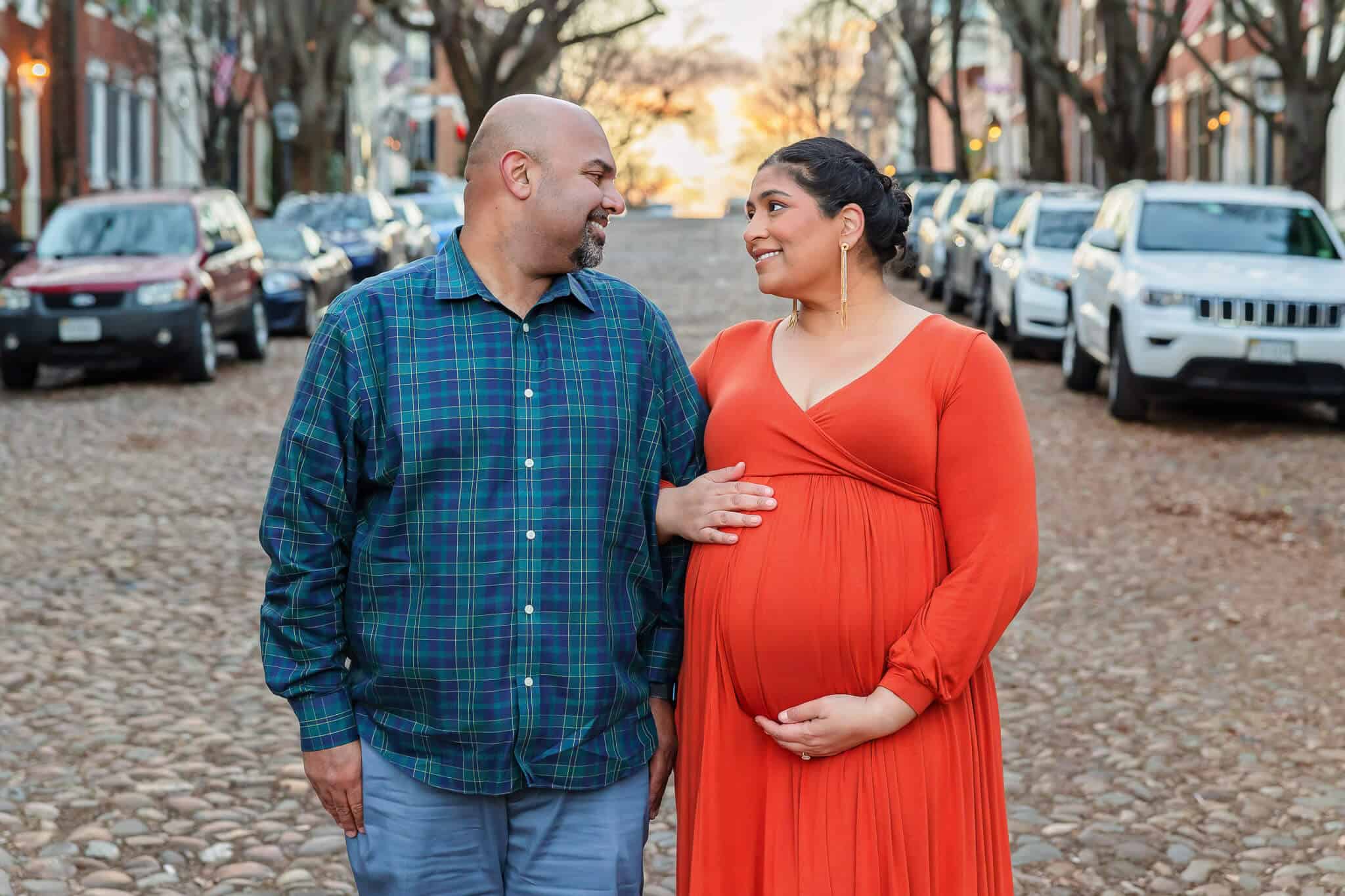 A pregnant couple looking at each other lovingly featured on a blog about Alexandria obgyns.