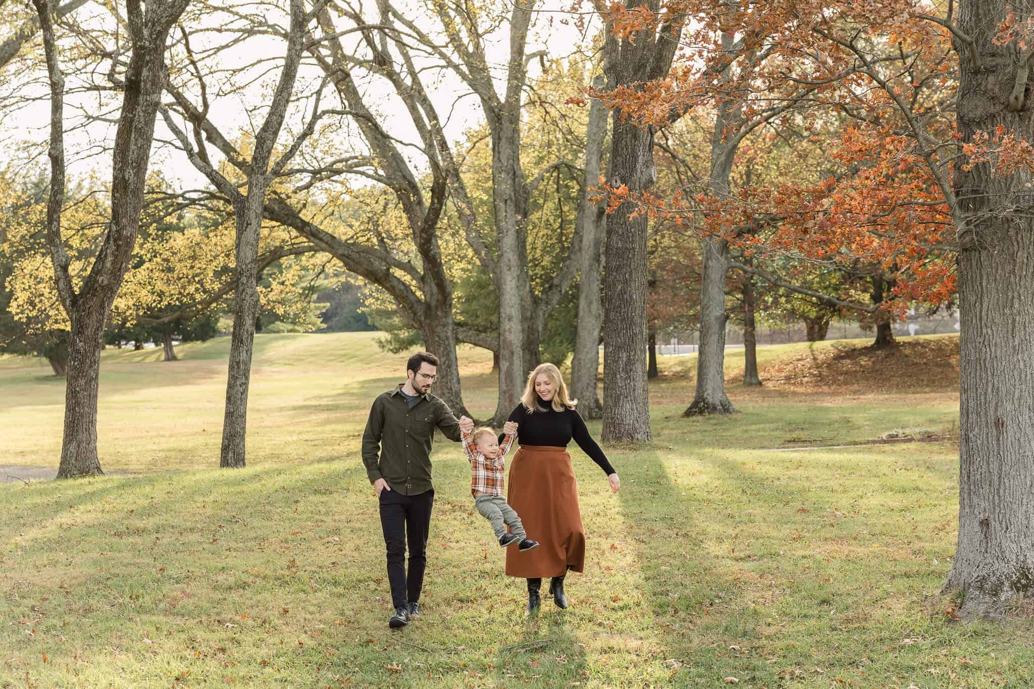 A mom and dad swinging their toddler between them at Sully Historic Site, one of my favorite photoshoot locations in Northern Virginia.