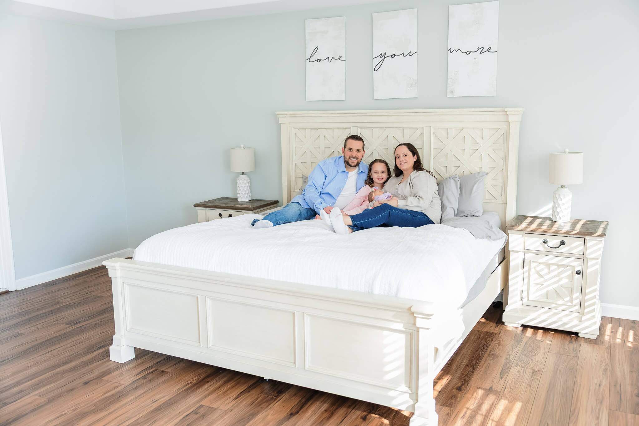 A family of four snuggled on the bed for their in home newborn photos.