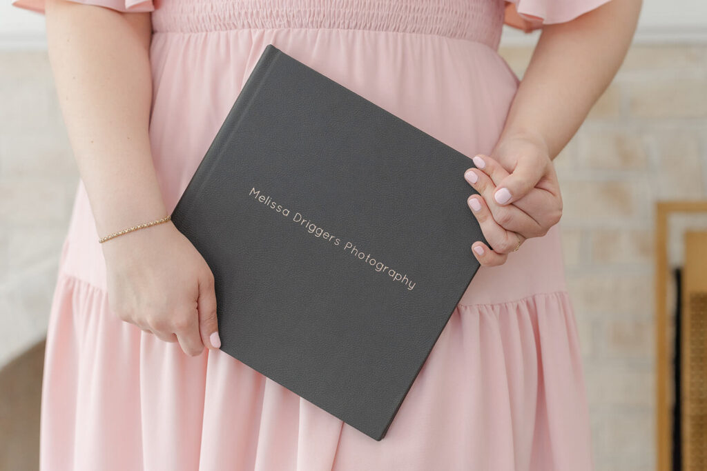 Layflat photo book with a gray cover and a debossed name